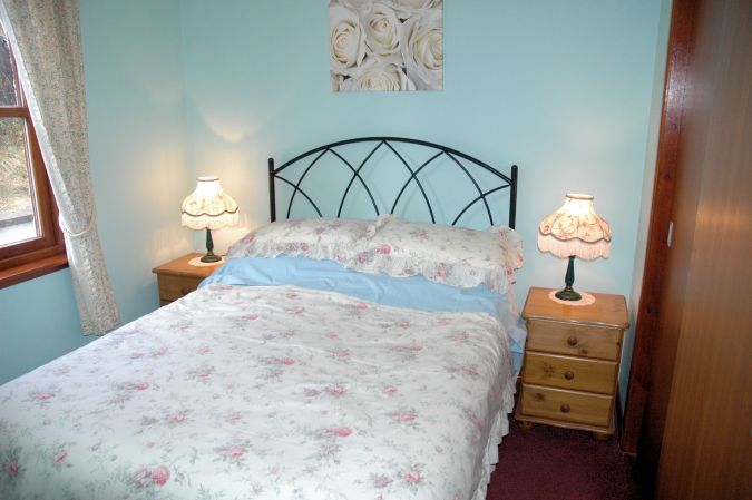 The Double Bedroom is comfortably appointed with bedside tables and lamps, and a built-in wardrobe.
